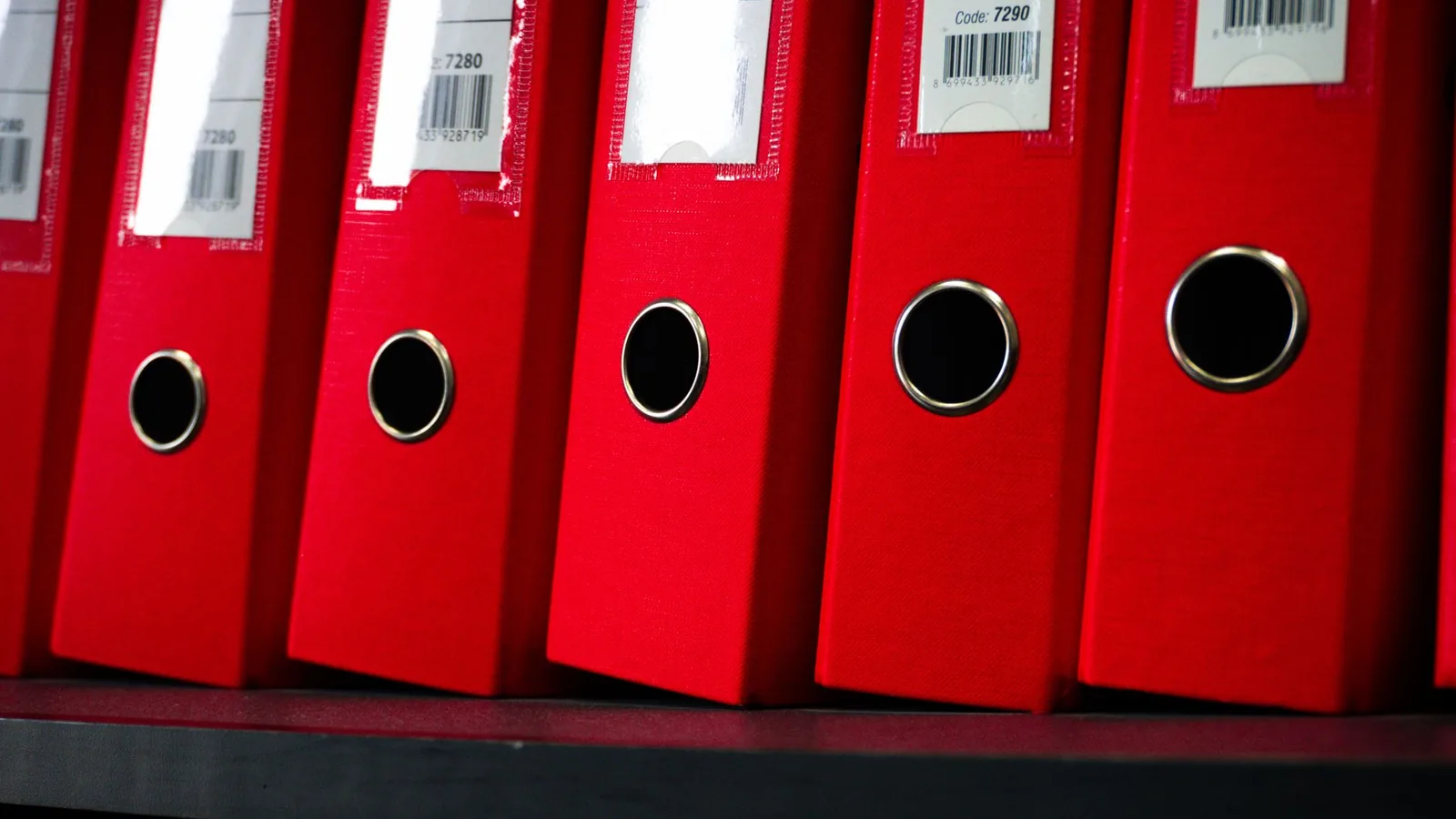Close up view of red office binders neatly organized on a shelf